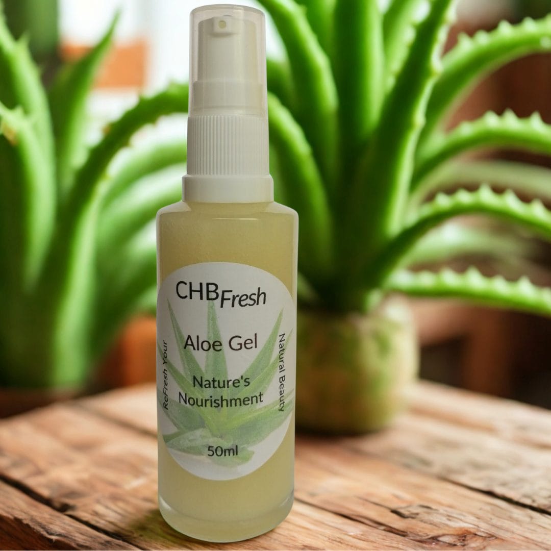 Aloe gel on wooden table with aloe plants in the background