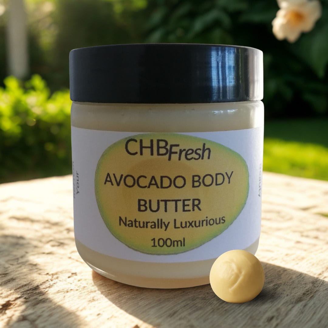 Avocado Body Butter with a butter ball on a wooden table in a garden