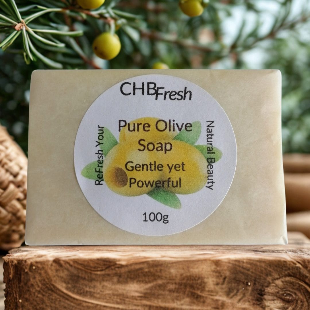 Pure Olive wrapped Soap on a shelf with an olive plant behind it