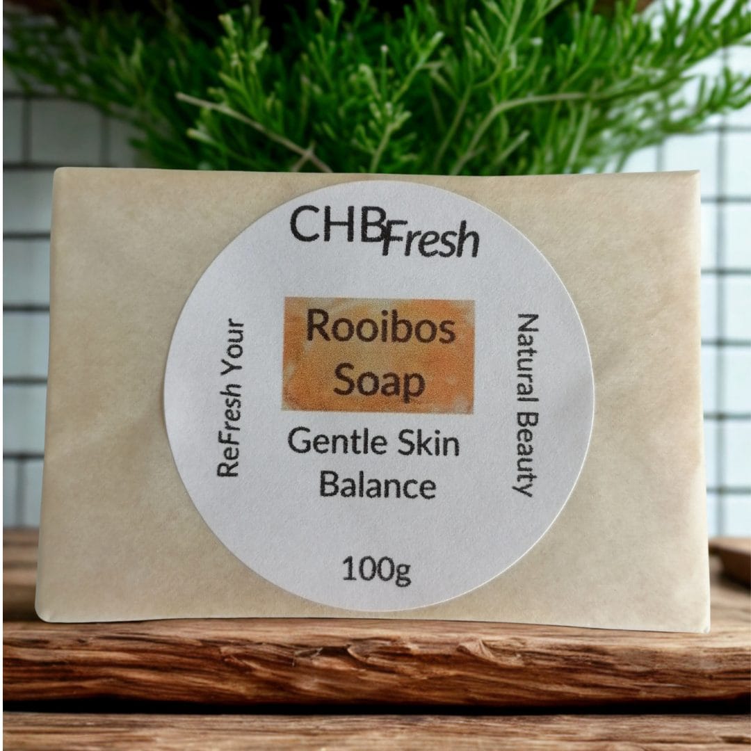 Rooibos Soap Wrapped on wooden shelf with rooibos plant behind it